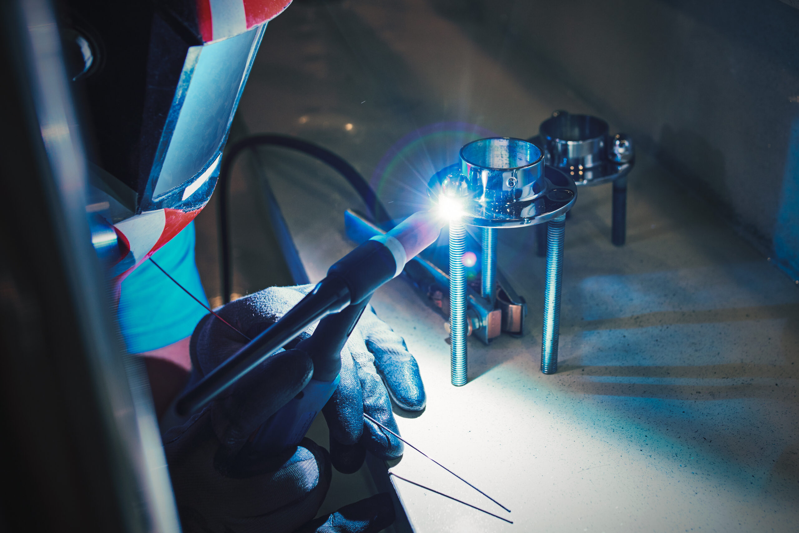 Men's hands with argon welding machine. repair pipe stainless argon welding industrial construction